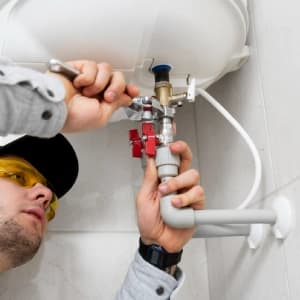 Chauffagiste réalisant une installation de chauffe-eau en Alsace